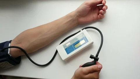 Guy measures himself pressure with the help of the device 스톡 동영상 80358681