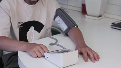 Guy measures the pressure with an electronic device at home Stock Footage 201213955