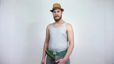 Guy measures tape a cucumber sticking out of his pants. Stock Footage 129402920