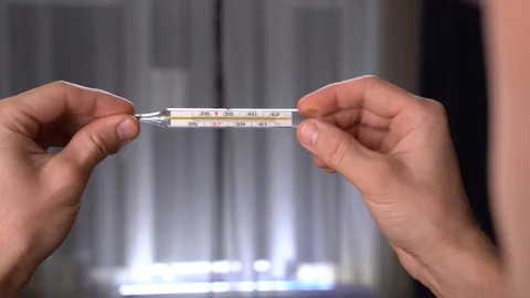 The guy measures the temperature with a thermometer Stock Footage 128691908