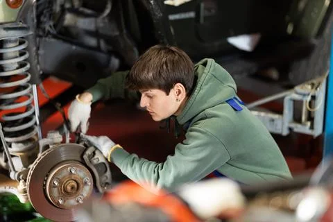 Guy mechanic fixes a wheel disc Stockfoto's