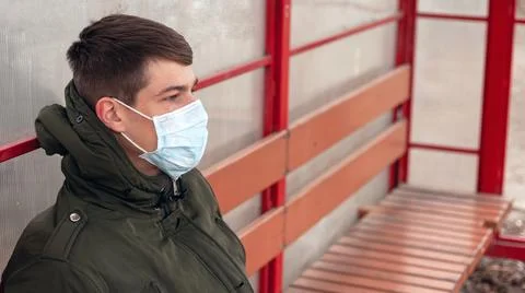 The guy in the medical mask at the bus stop,lockdown coronavirus pandemic Stock-Fotos