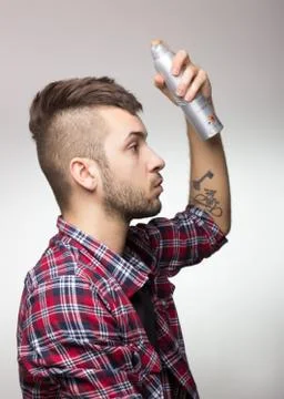 Guy with mohawk putting hairspray. Stock Photos