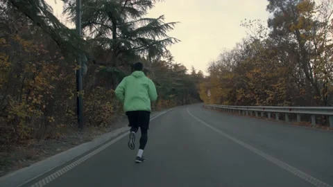 The guy on a morning run in the park on a background of trees Video stock 239552278