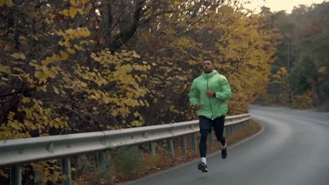 The guy on a morning run in the park on a background of trees Video stock 239552294