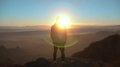 The guy on a morning run standing at the top of mountains . Video stock 239555984