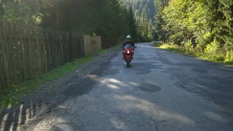 A guy on a motorcycle. Young handsome guy rides a motorcycle on a mountain road. Stock Footage 95907982