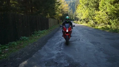 A guy on a motorcycle. Young handsome guy rides a motorcycle on a mountain road. Stock Footage 95908136