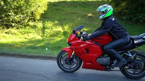 A guy on a motorcycle. Young handsome guy rides a motorcycle on a mountain road. Stock Footage 95909750