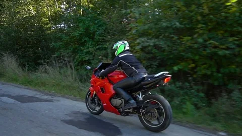 A guy on a motorcycle. Young handsome guy rides a motorcycle on a mountain road. Stock Footage 95911497