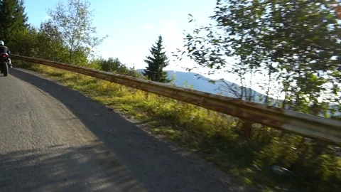 A guy on a motorcycle. Young handsome guy rides a motorcycle on a mountain road. Stock Footage 95970528