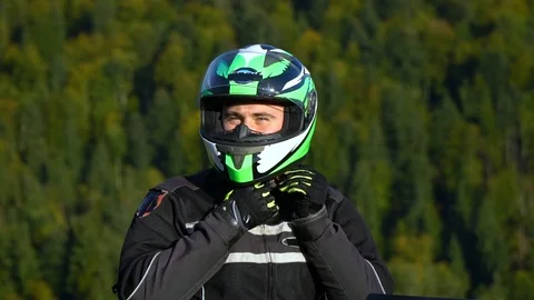 A guy on a motorcycle. Young handsome guy with his motorcycle in the mountains Stock Footage 95971573