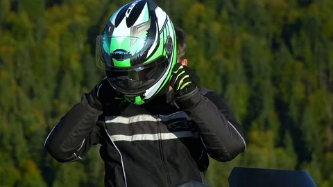 A guy on a motorcycle. Young handsome guy with his motorcycle in the mountains Video stock 95971706
