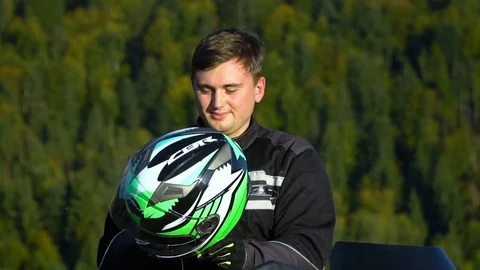 A guy on a motorcycle. Young handsome guy with his motorcycle in the mountains Stock Footage 95979885