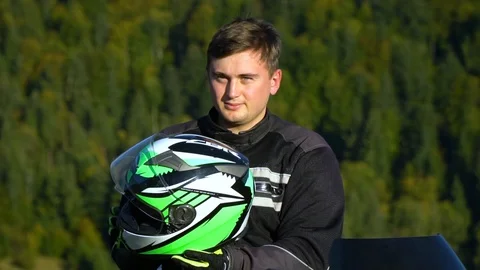 A guy on a motorcycle. Young handsome guy with his motorcycle in the mountains Stock Footage 96032336