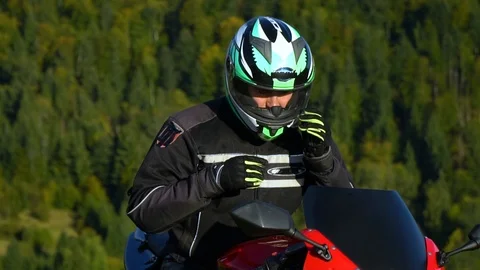 A guy on a motorcycle. Young handsome guy with his motorcycle in the mountains Stock Footage 96032407