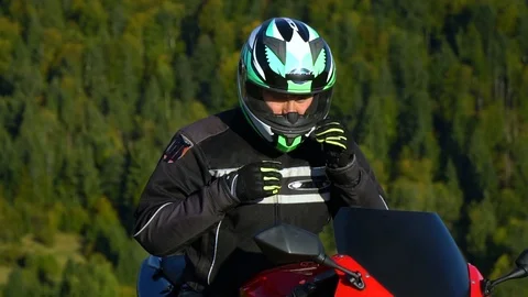 A guy on a motorcycle. Young handsome guy with his motorcycle in the mountains Stock Footage 96032674