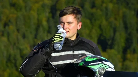 A guy on a motorcycle. Young handsome guy with his motorcycle in the mountains 스톡 동영상 96032802