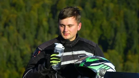 A guy on a motorcycle. Young handsome guy with his motorcycle in the mountains Stock Footage 96033143