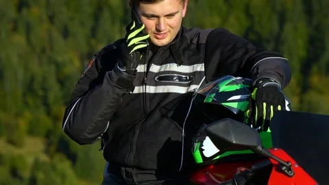 A guy on a motorcycle. Young handsome guy with his motorcycle in the mountains Stock Footage 96033572