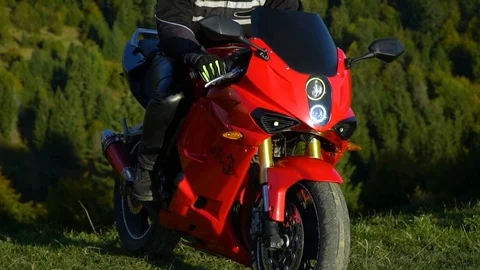 A guy on a motorcycle. Young handsome guy with his motorcycle in the mountains. Video stock 96033702