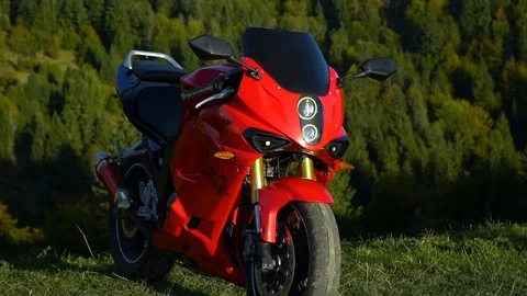 A guy on a motorcycle. Young handsome guy with his motorcycle in the mountains Stock Footage 96044384