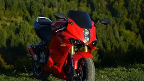 A guy on a motorcycle. Young handsome guy with his motorcycle in the mountains Video stock 96044525