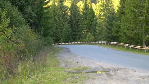A guy on a motorcycle. Young handsome guy rides a motorcycle on a mountain road. Stock Footage 96152820