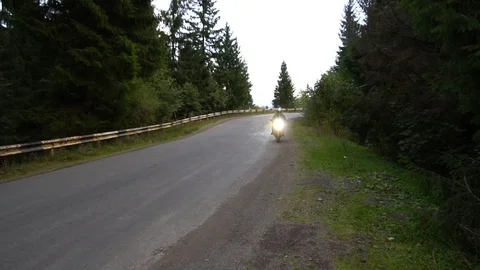 A guy on a motorcycle. Young handsome guy rides a motorcycle on a mountain road. Stock Footage 96154276