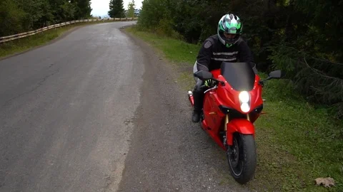 A guy on a motorcycle. Young handsome guy rides a motorcycle on a mountain road. Stock Footage 96154844