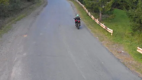 A guy on a motorcycle. Young handsome guy rides a motorcycle on a mountain road Stock Footage 96155908