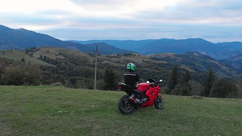 A guy on a motorcycle. Young handsome guy rides a motorcycle on a mountain road Stock Footage 96156645