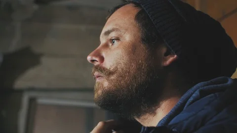A guy with a mustache and beard with beautiful blue eyes combing his beard wi Stock Footage 103300147