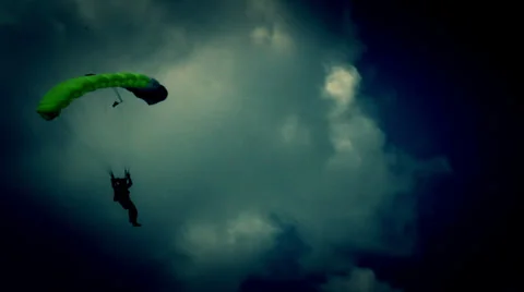 A guy on the neon green parachute safely lands on an open area 動画素材 32116590