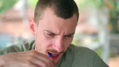 The guy nervously and thoughtfully chews on his pen and looks at the camera. Stock Footage 231336675