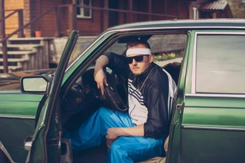 Guy in the nineties sits behind the wheel of a car Stock Photos