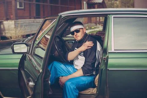 Guy in the nineties sits behind the wheel of a car Stock Photos