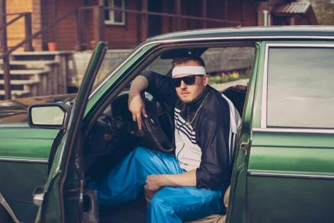 Guy in the nineties sits behind the wheel of a car Stock Photos