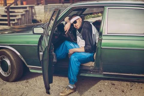 Guy in the nineties sits behind the wheel of a car Stock Photos