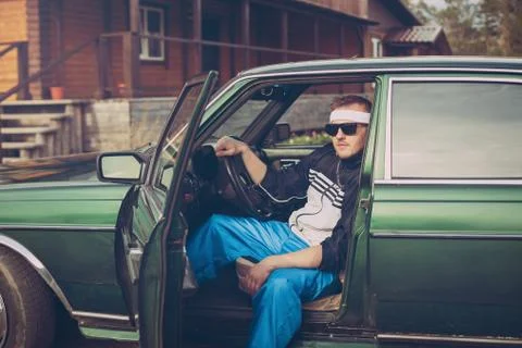 Guy in the nineties sits behind the wheel of a car Stock Photos