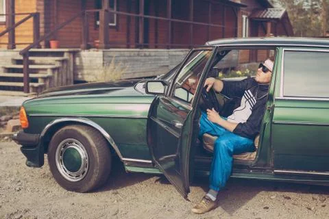 Guy in the nineties sits behind the wheel of a car Stock Photos