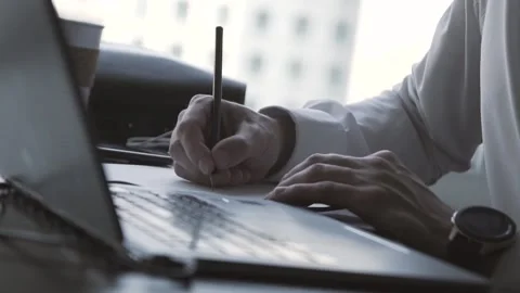 The guy in the office. The guy is working. The guy behind the phone and laptop Stock Footage 130732063