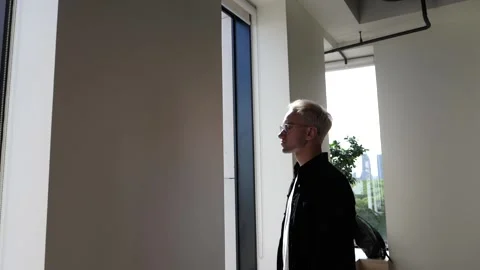 The guy in the office is standing by the window Stock Footage 138874426