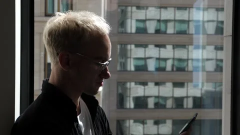 The guy in the office is standing by the window Stock Footage 138874456