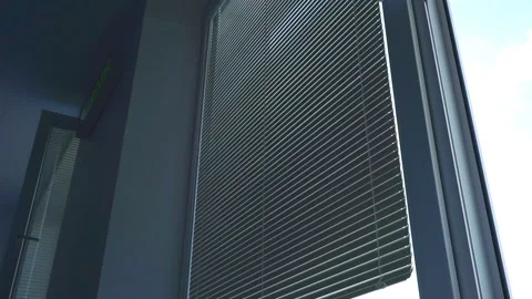 Guy opens the blinds and looks out the window. Stock Footage 96336931