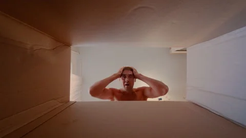 The guy opens the box, is surprised and tries to touch the contents. Stock Footage 316911568