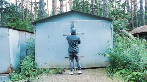 The guy opens the garage door with a key and goes inside Stock Footage 113859260