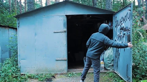 The guy opens the garage door with a key and goes inside Stock Footage 113859322