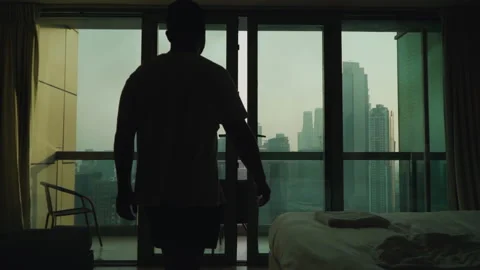 The guy opens the panoramic window. Apartment on a very high floor in Dubai 스톡 동영상 167737129