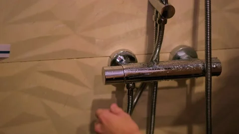 The guy opens the water in the shower room Stock Footage 162960486